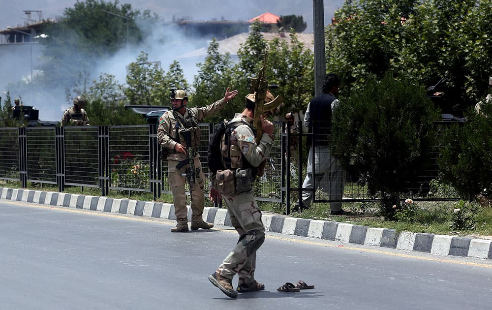 Afghan security forces inspect at the site of a suicide attack during clashes with Taliban fighters in front of the Parliament, in Kabul, Afghanistan.