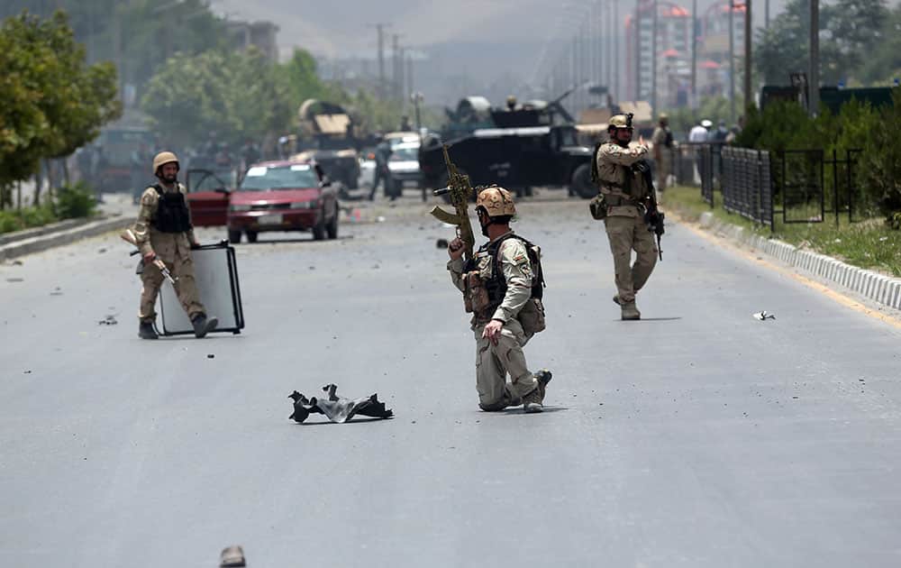 Afghan security forces take position at the site of a suicide attack during clashes with Taliban fighters in front of the Parliament, in Kabul, Afghanistan.