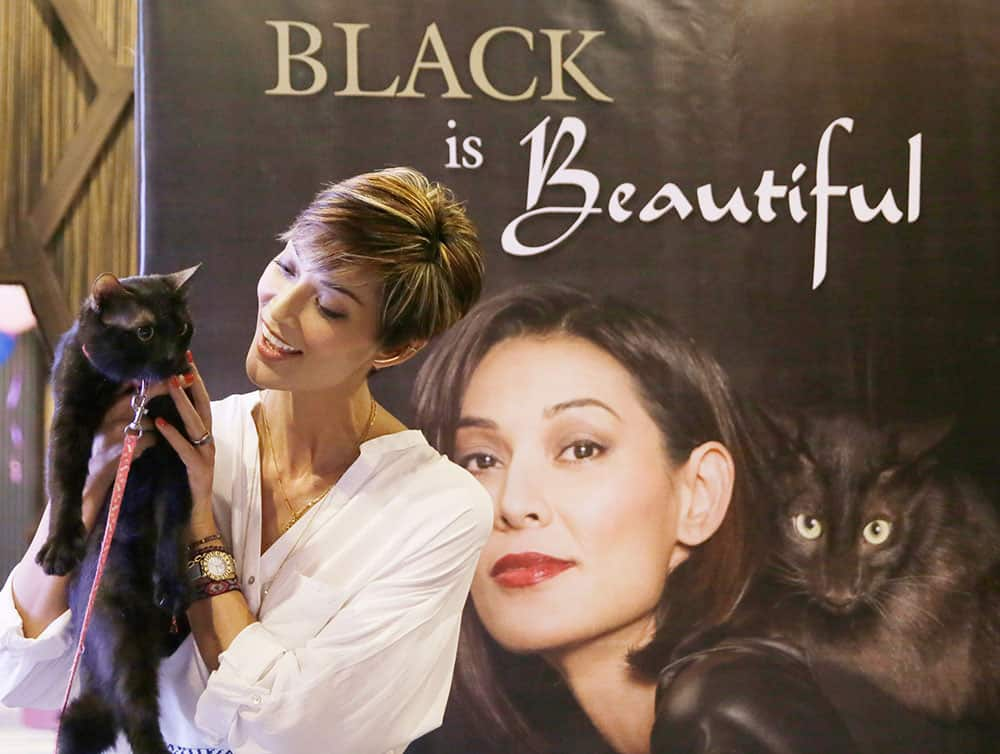 Filipino model and television personality Joey Mead holds a black cat named 