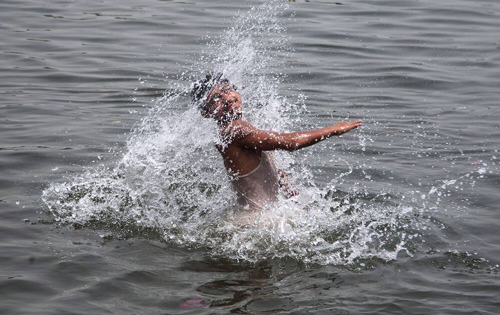 A Pakistani boy cools himself in polluted water near a port during a high heat wave, in Karachi, Pakistan.