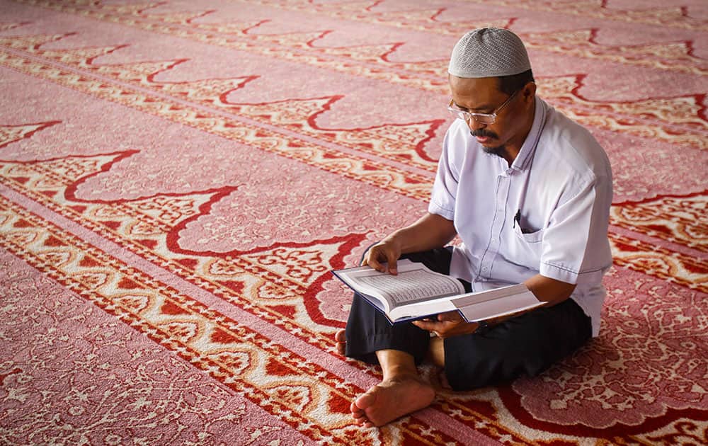 A Malaysian Muslim man recites the Holy Quran, before the Zohar prayers at a mosque during Islam's holy month of Ramadan, in Putrajaya, Malaysia.