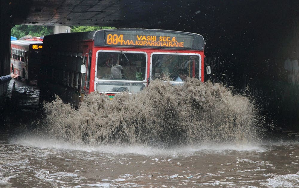 Vehicles wade through a water logged road after heavy downpour in Mumbai.