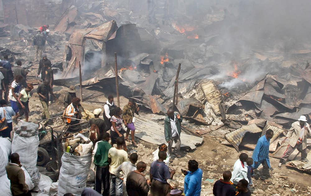 Residents look at the remains of market stalls after an overnight fire in the Gikomba open-air market in Nairobi, Kenya.