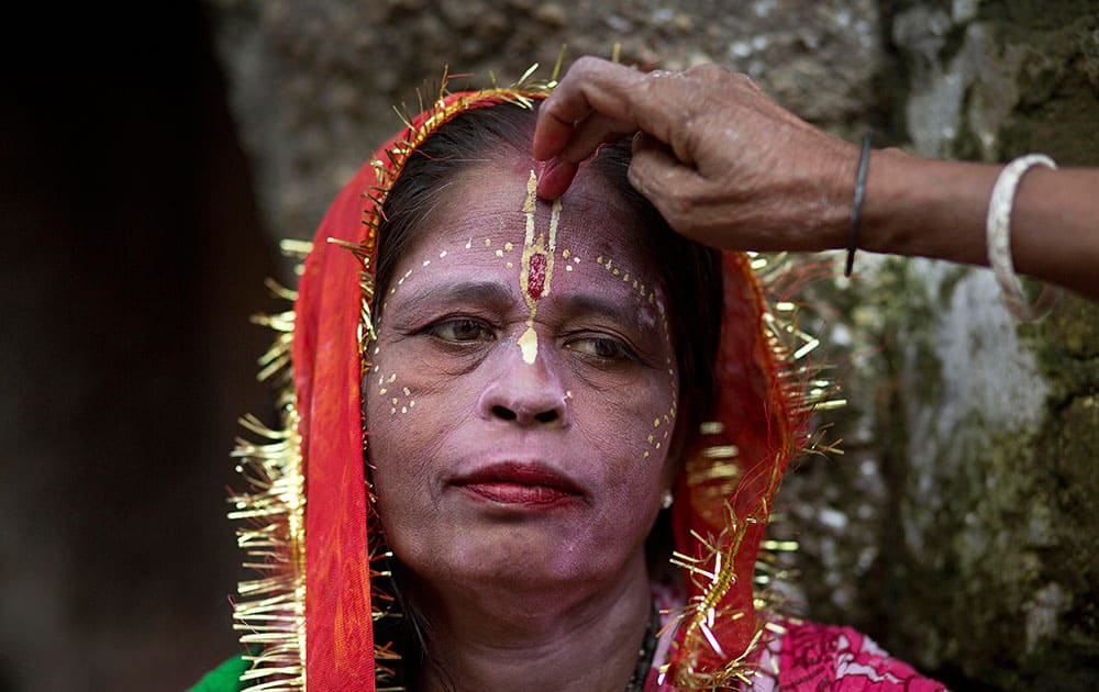 A woman devotee is helped get ready at the Kamakhya temple in Gauhati, India.