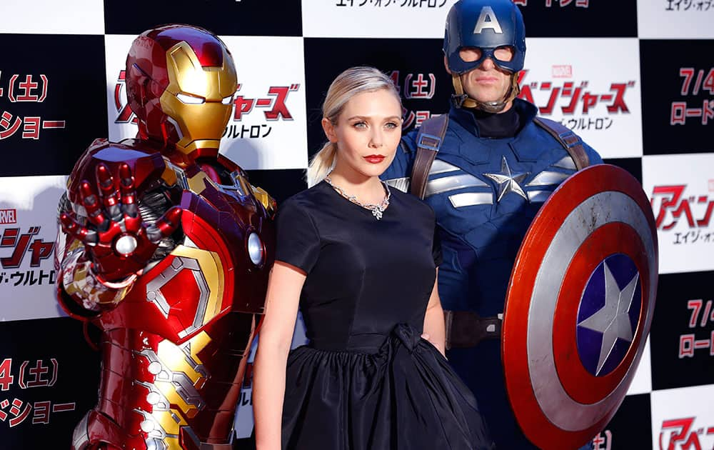 U.S. actress Elizabeth Olsen, center, poses for photographers with Iron man, left, and Captain America during the Japan premiere of Avengers: Age of Ultron in Tokyo.