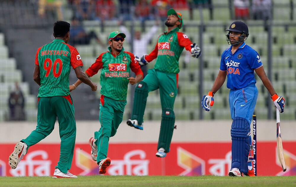 Mustafizur Rahman celebrates with teammate Nasir Hossain and Litton Das after the dismissal of Rohit Sharma during their third one-day international cricket match in Dhaka.