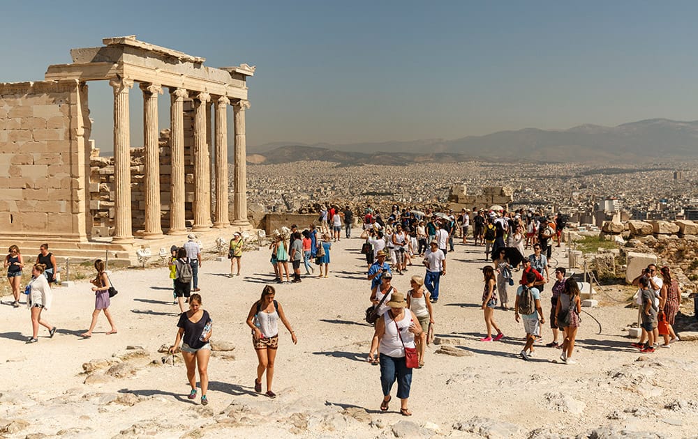 Tourists walk on Acropolis Hill, an ancient sanctuary of ancient Athens.