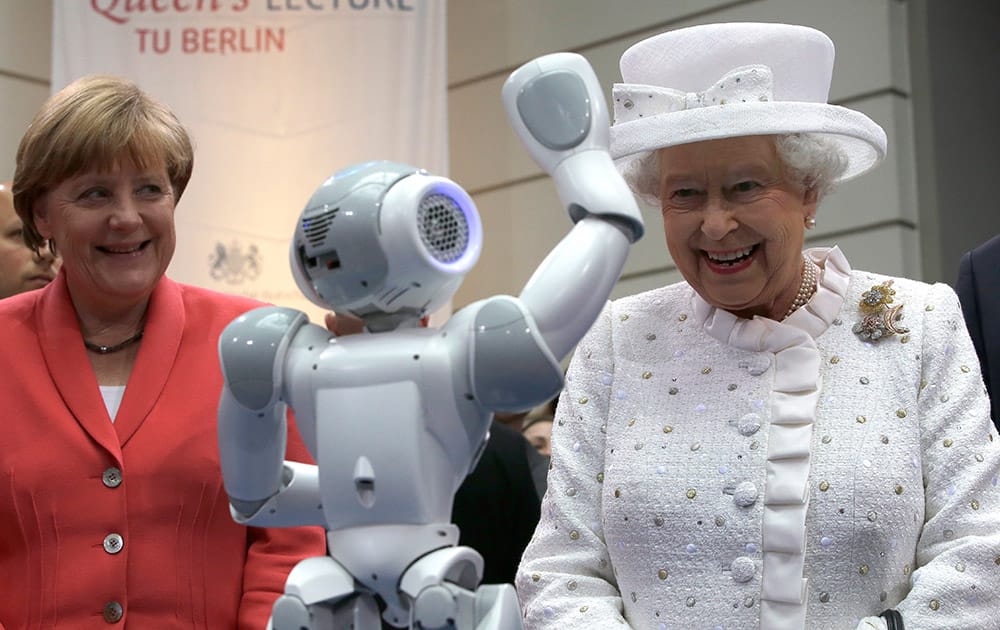 German Chancellor Angela Merkel and Britain's Queen Elizabeth II smile as a little robot waves to the Queen during a reception at the 'Technische Universitaet' (Technical University) in Berlin, Germany.