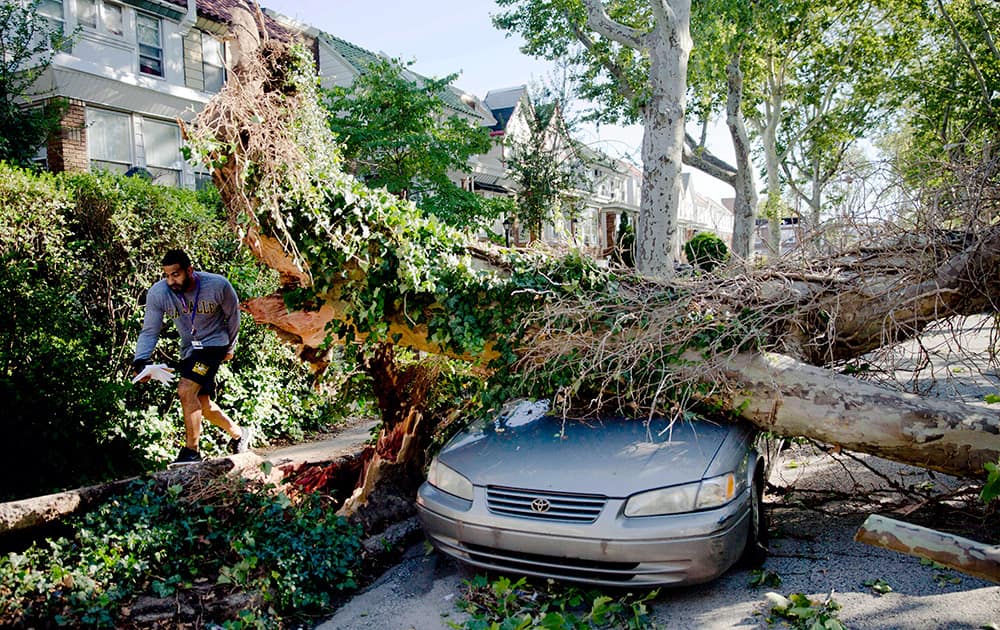A man walks past damage on Sylvester Street in the aftermath of a storm in Philadelphia.