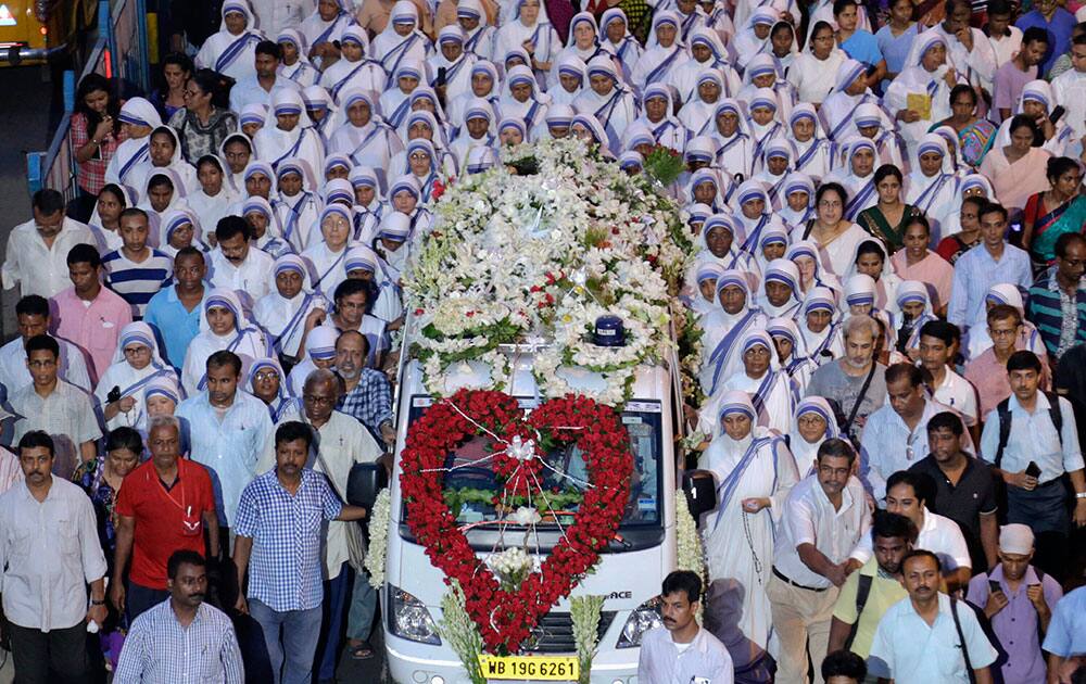 Nuns and others walk beside the garlanded coffin of Sister Nirmala Joshi during her funeral procession in Kolkata, India.