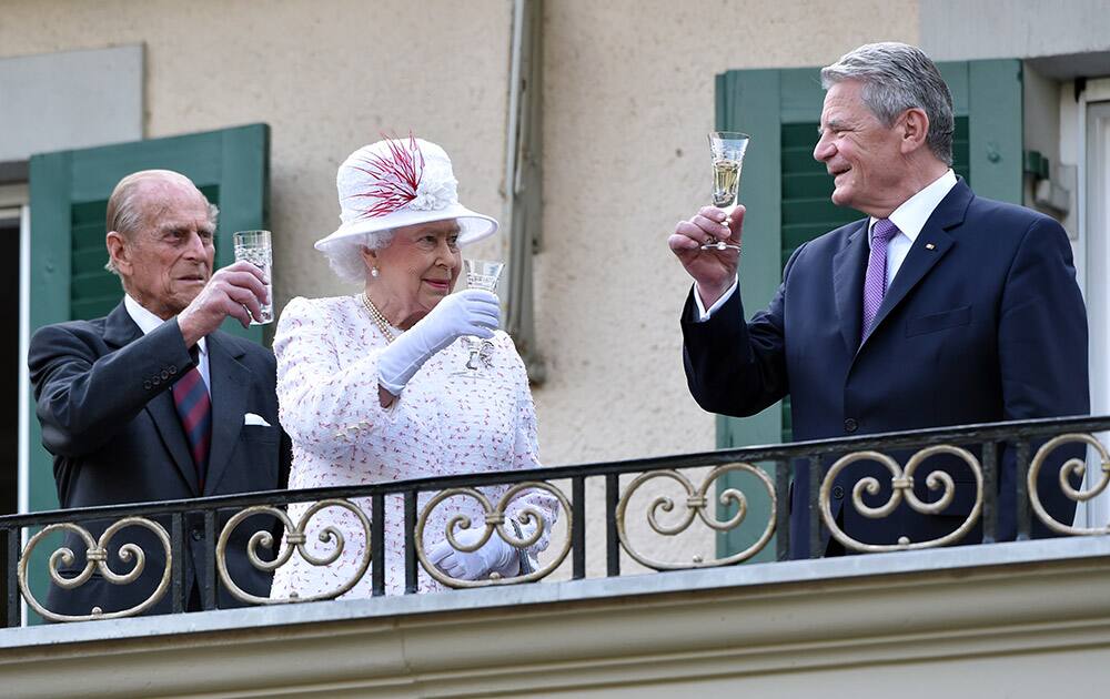 Britain's Queen Elizabeth II , center, Prince Philip. left, and German president Joachim Gauck, right, toast on the balcony of the British ambassador's residence, as they attend the birthday party for the Queen in Berlin.
