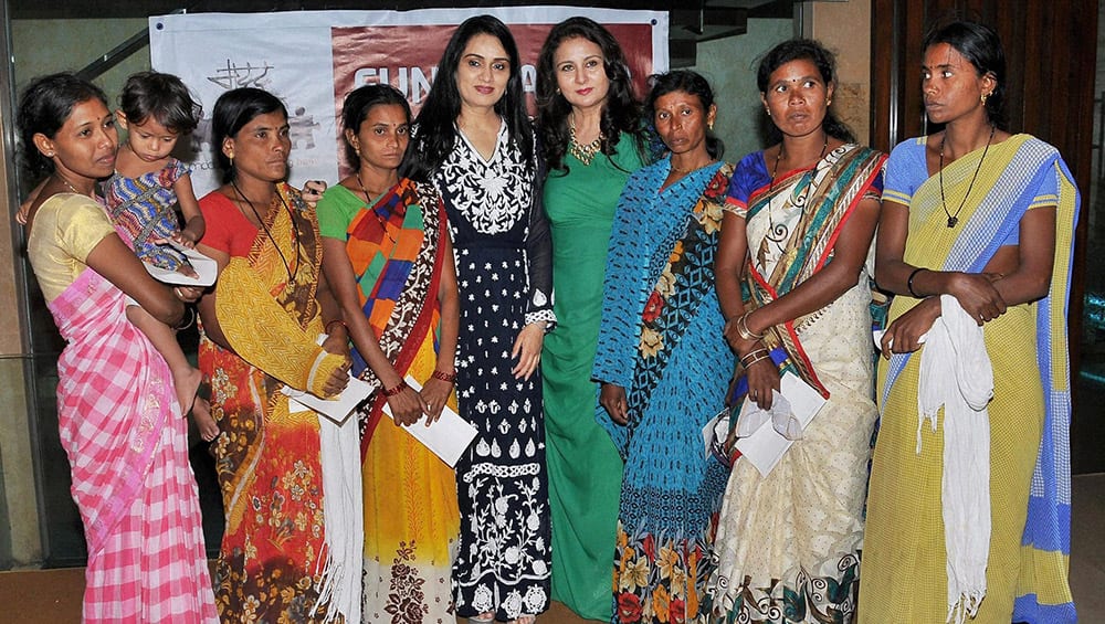 Actress Poonam Dhillon and Padmini Kolhapure pose for a group photo with family members of underprivileged farmers of Vidharbha during an event organized by a NGO MADDAD , in Mumbai.