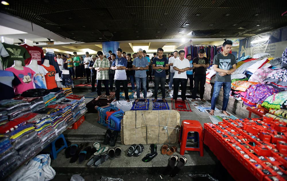 Indonesian Muslim men pray during Friday prayer at a market in Jakarta, Indonesia.