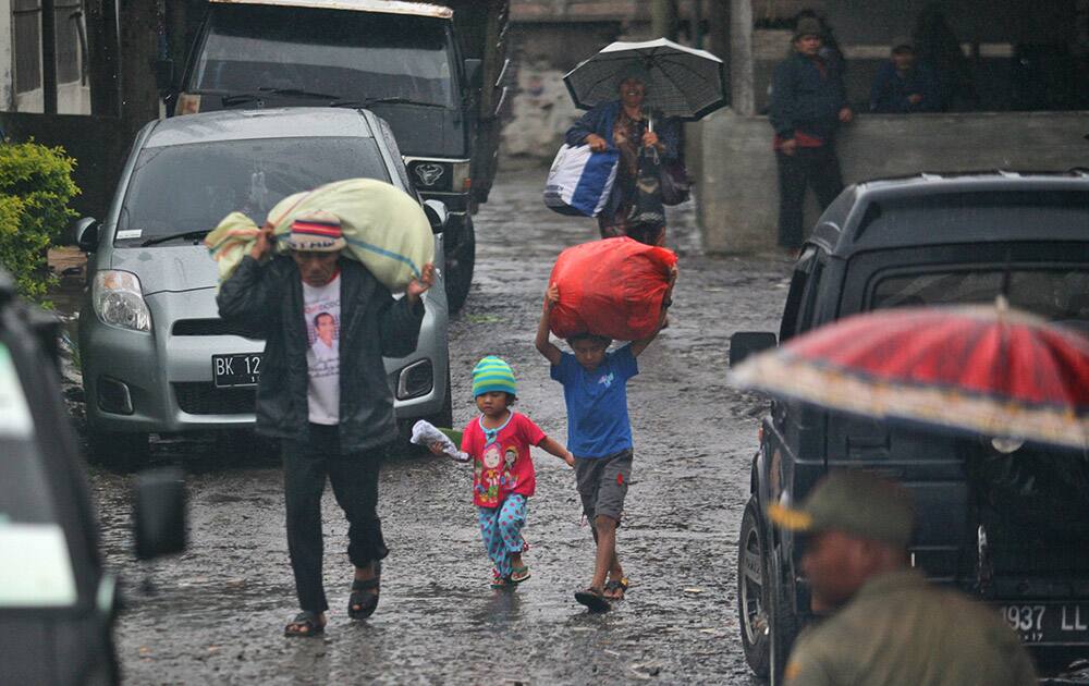 Villagers carry their belongings as they are evacuated from their homes on the slope of Mount Sinabung in Kuta Tengah, North Sumatra, Indonesia.