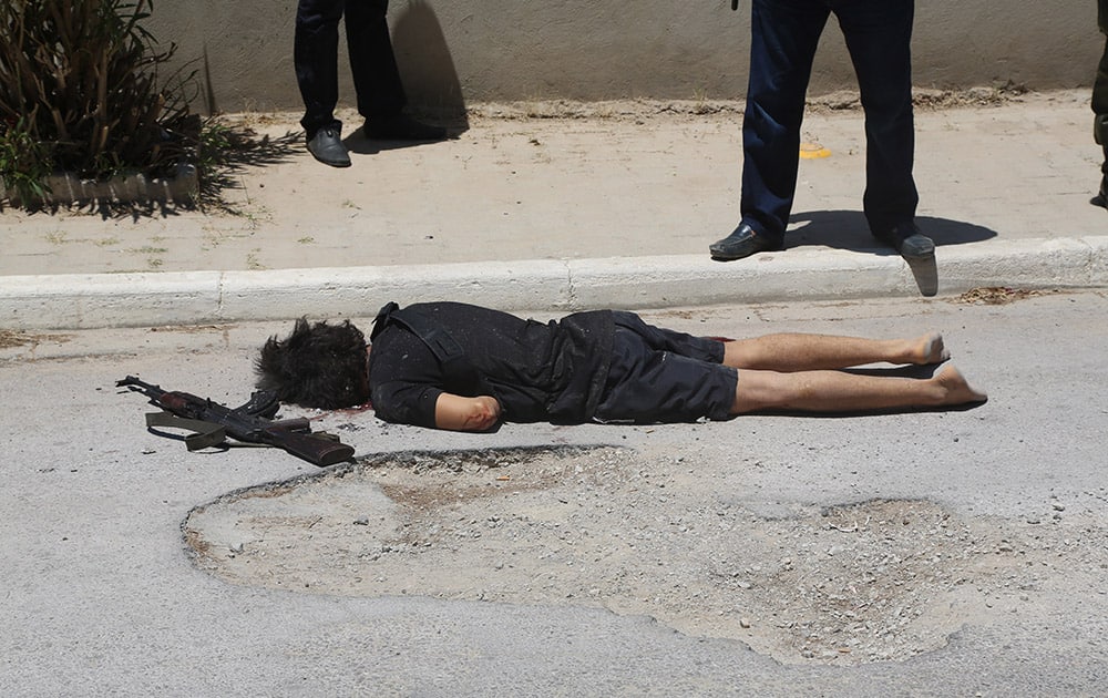 The body of the attacker Seifeddine Rezgui lies on the ground in the costal town of Sousse, Tunisia. Tunisia's Prime Minister says an initial investigation shows the gunman who killed tens of people at a beach resort was from a village in a poor central region of Tunisia and had never traveled abroad. 