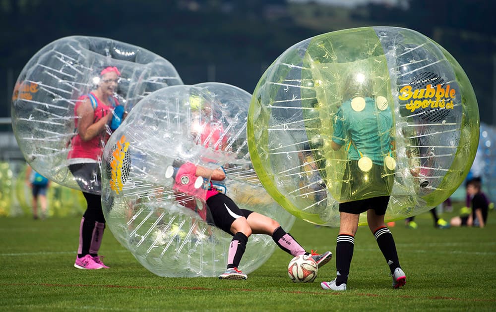 Two soccer teams fight for the ball during a bubble ball soccer tournament in Hitzkirch, central Switzerland.