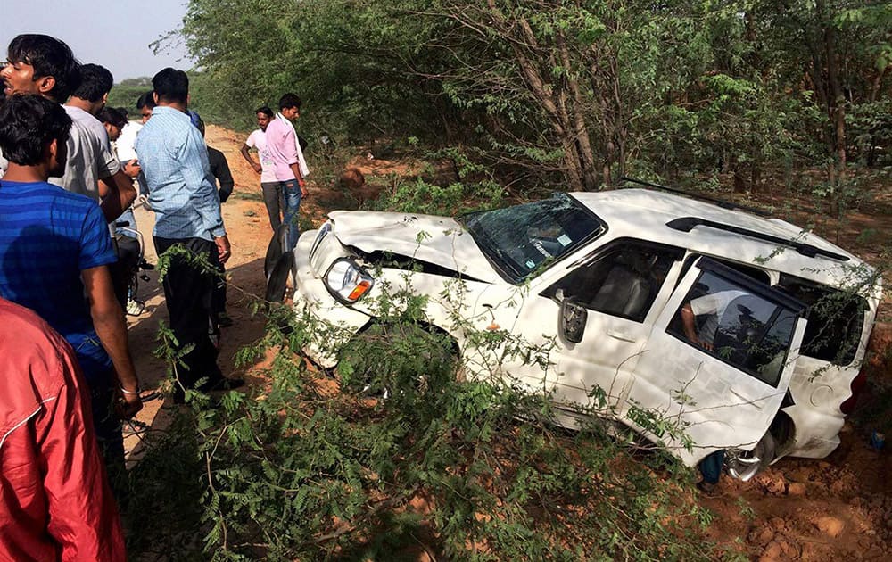 People gathered around wrecked SUV that rolled down the road after an accident at Gurgaon-Faridabad road in Faridabad.