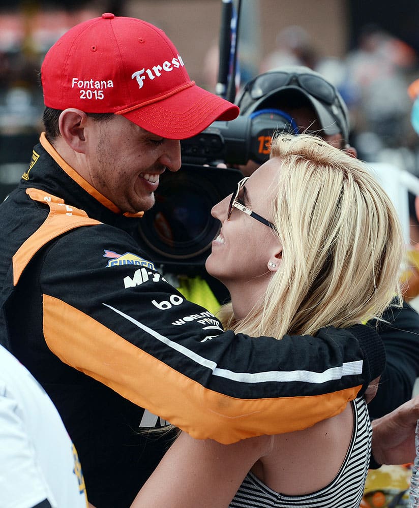 Graham Rahal (15) celebrates with his fiancee, NHRA Funny Car driver Courtney Force, after winning the IndyCar auto race at Auto Club Speedway in Fontana, Calif.