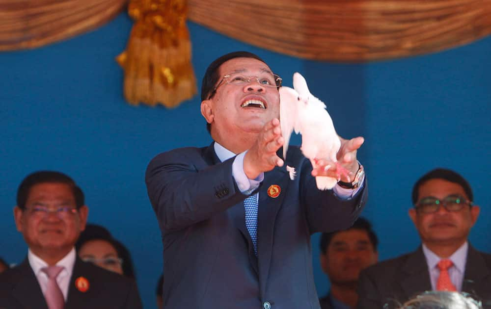 Cambodian Prime Minister Hun Sen, who is also President of Cambodian People's Party, CPP, center, releases a dove during the party's 64th anniversary at its headquarters, in Phnom Penh, Cambodia.