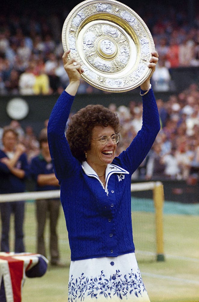 In this July 4, 1975 file photo, U.S. tennis star Billie Jean King holds up the trophy after winning her sixth singles final at the All England Lawn Tennis Championships in Wimbledon, London.