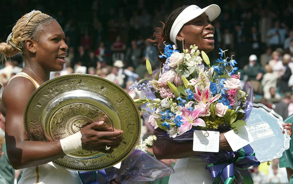 In this July 6, 2002 file photo, Serena Williams, left, holds her trophy after defeating her sister Venus, right, to win the Women's Singles final on the Centre Court at the All England Lawn Tennis Championships in Wimbledon, London.