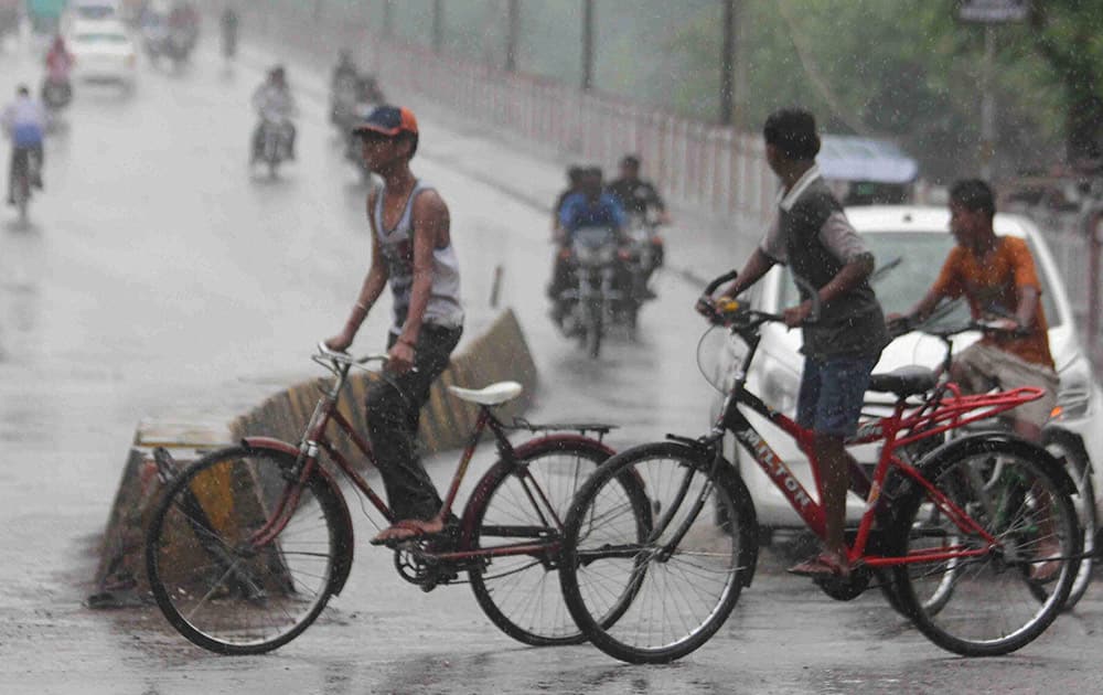 People commuting on road during heavy rains in Allahabad.