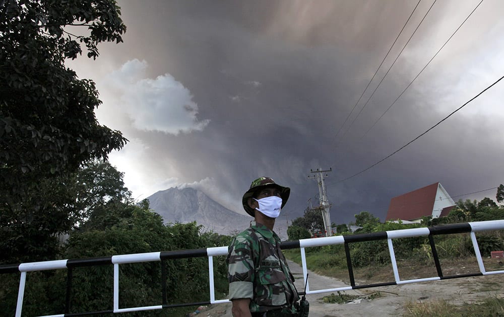 An Indonesian soldier mans a check point on a road leading to the area marked as danger zone on the slopes of Mount Sinabung in Sibintun, North Sumatra, Indonesia.