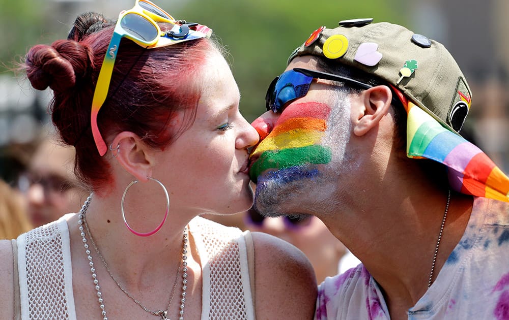 Andrew Parker, right, kisses Stacy Washack as they celebrate during the 46th Annual Chicago Pride Parade, in Chicago. 