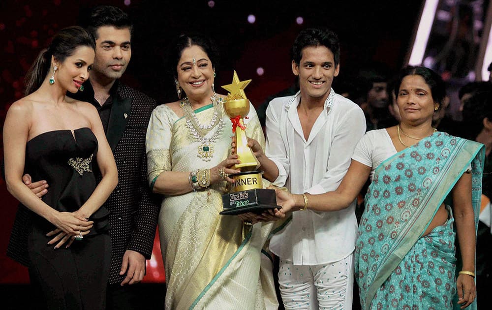 Bollywood actress Malaika Arora Khan, Kirron Kher and filmmaker Karan Johar award the winner during the grand finale of Indias Got Talent in Mumbai.