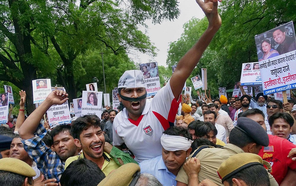 Workers of AAP holding a protest to demand the resignation of the Union Ministers Smriti Irani and Sushma Swaraj and Rajasthan CM Vasundhra Raje and Pankaja Munde in New Delhi.