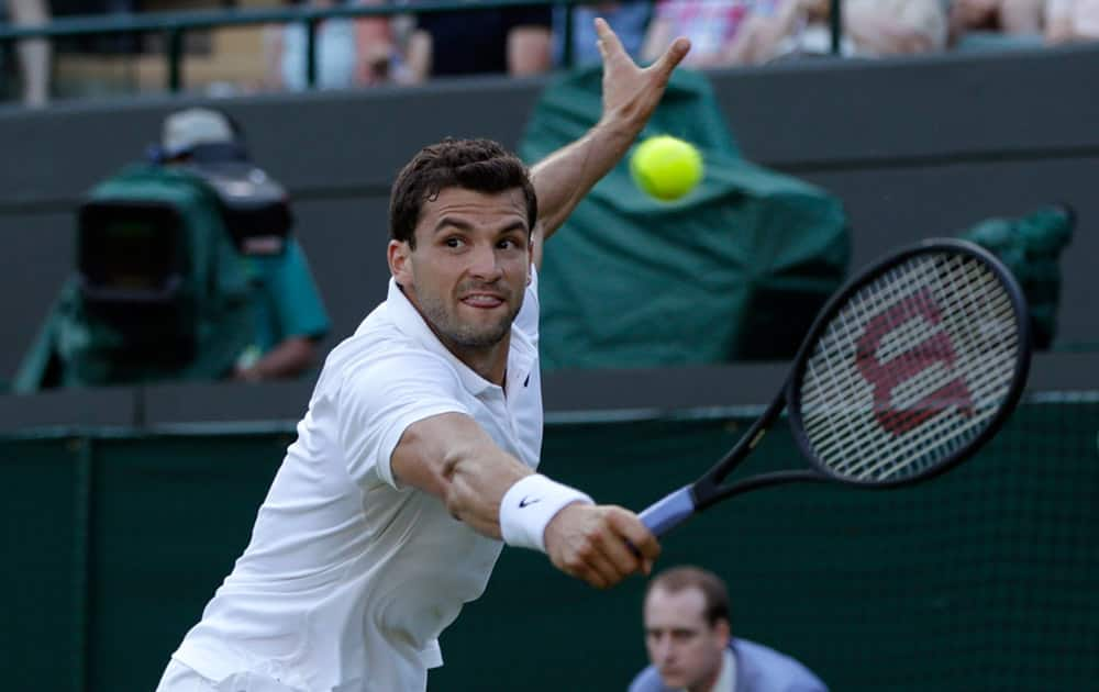 Grigor Dimitrov of Bulgaria returns a ball to Federico Delbonis of Argentina during the men's singles first round match at the All England Lawn Tennis Championships in Wimbledon, London.