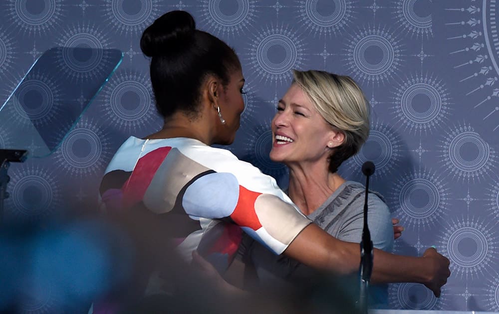 First lady Michelle Obama hugs actress Robin Wright as she arrives to speak at the MORE Magazine's first-ever MORE Impact Awards Luncheon at the Newseum in Washington.