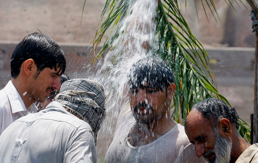 People cool themselves off with water in Peshawar, Pakistan, during the Muslim fasting month of Ramadan. 