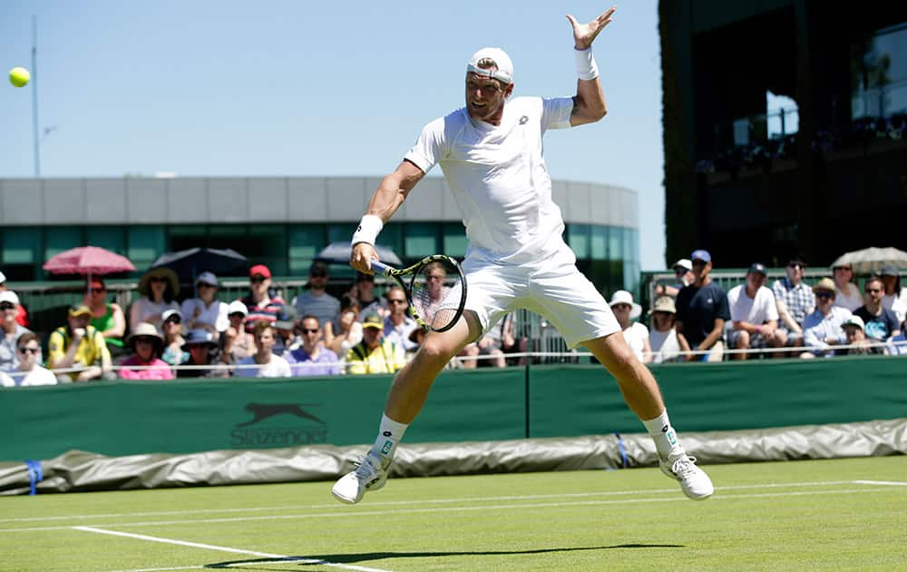 Sam Groth of Australia plays a return to Jack Sock of the United States during the men's singles first round match at the All England Lawn Tennis Championships in Wimbledon, London.