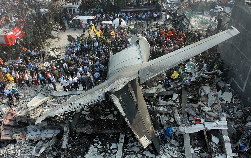 Rescuers search for victims at the site where an air force cargo plane crashed in Medan, North Sumatra, Indonesia.