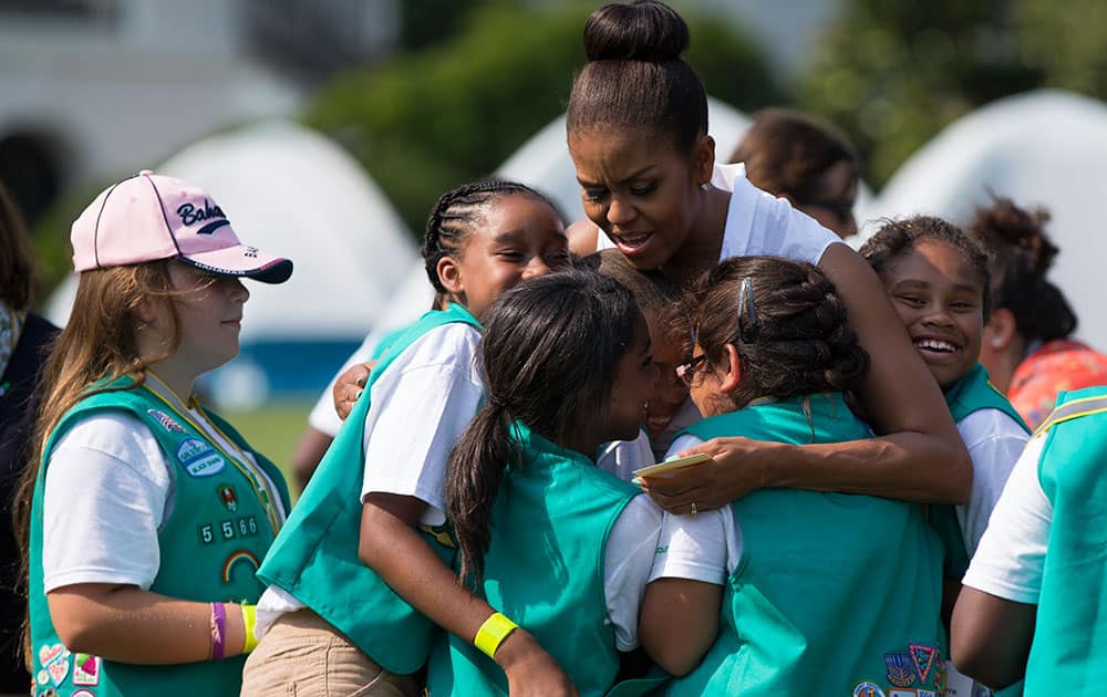 First lady Michelle Obama hugs a group of Girl Scouts during a Lets Move! event on the South Lawn of the White House, in Washington.