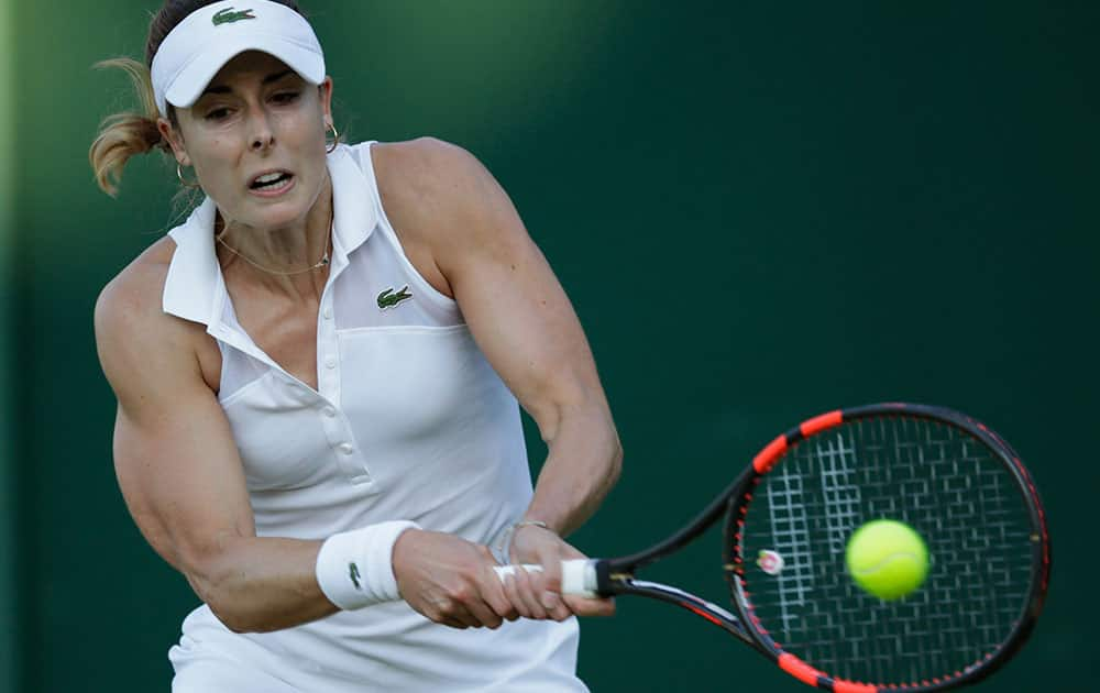 Alize Cornet of France plays a return to Ana Konjuh of Croatia during their women's singles first round match at the All England Lawn Tennis Championships in Wimbledon, London.