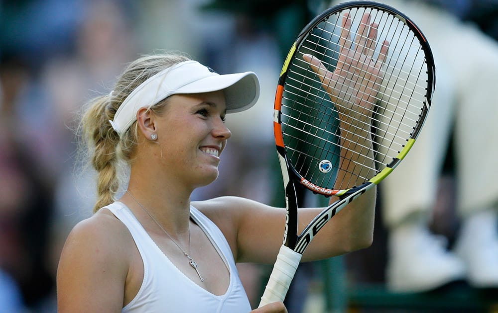 Caroline Wozniacki of Denmark celebrates defeating Saisai Zheng of China in their singles first round match at the All England Lawn Tennis Championships in Wimbledon, London. Wozniacki won the match 7-5, 6-0.