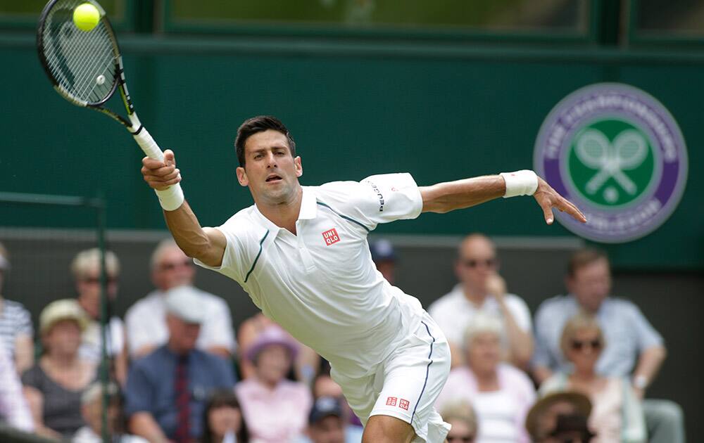 Novak Djokovic of Serbia serves to Jarkko Nieminen of Finland, during their singles match at the All England Lawn Tennis Championships in Wimbledon, London.
