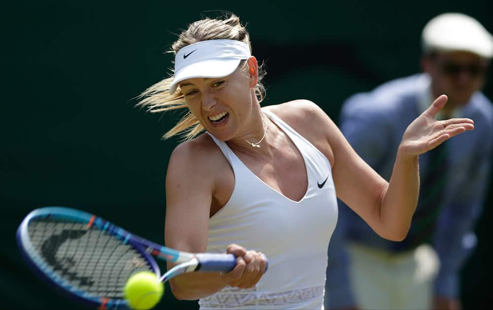 Maria Sharapova of Russia returns a shot to Richel Hogenkamp of the Netherlands, during their singles match at the All England Lawn Tennis Championships in Wimbledon, London.