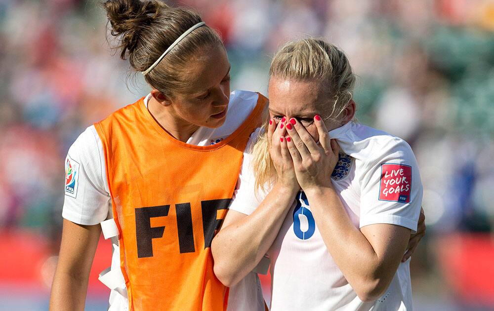 England's Josanne Potter, left, consoles Laura Bassett (6) after the team's 2-1 loss to Japan during a semifinal in the FIFA Women's World Cup soccer tournament, in Edmonton, Alberta, Canada. Japan won 2-1. 