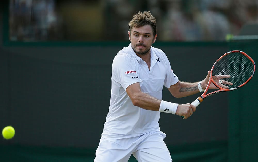 Stan Wawrinka of Switzerland returns a shot to Victor Estrella Burgos of the Dominican Republic, during their singles match at the All England Lawn Tennis Championships in Wimbledon, London.