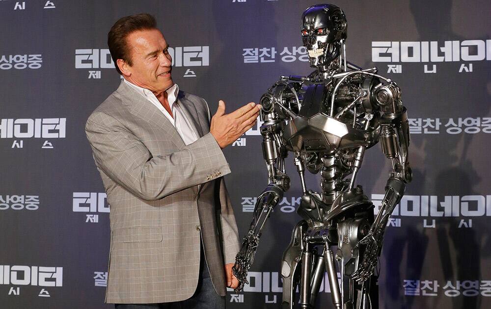 Actor Arnold Schwarzenegger stands with a model of a 'Terminator' from the new film 'Terminator Genisys' during a press conference at the Ritz Carlton hotel in Seoul, South Korea.