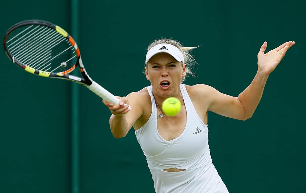 Caroline Wozniacki of Denmark makes a return to Denisa Allertova of the Czech Republic, during their singles match at the All England Lawn Tennis Championships in Wimbledon, London.