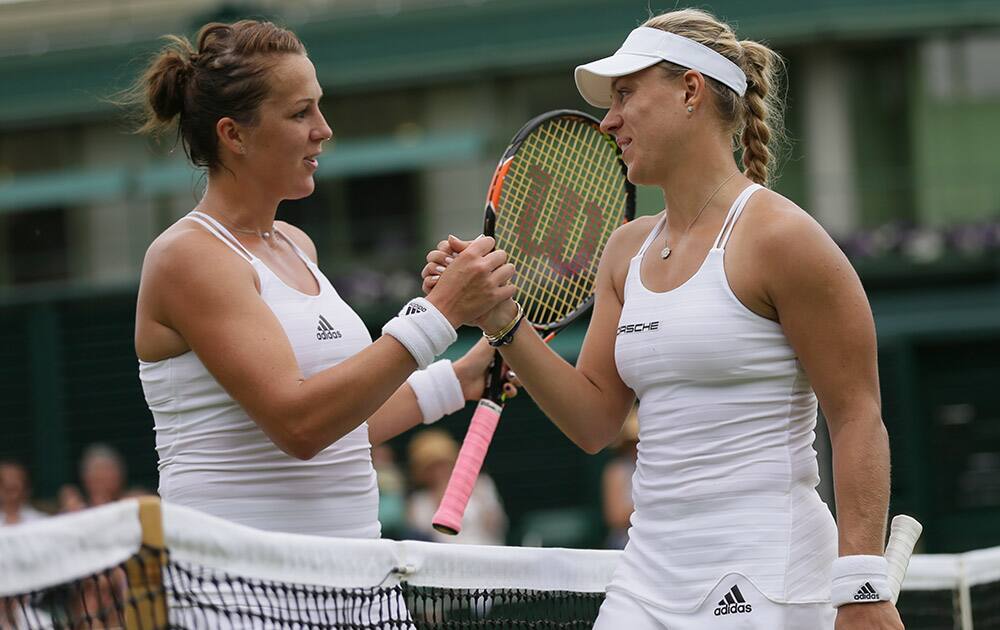 Angelique Kerber of Germany shakes hands at the net with Anastasia Pavlyuchenkova of Russia after defeating her during their singles match at the All England Lawn Tennis Championships in Wimbledon, London.