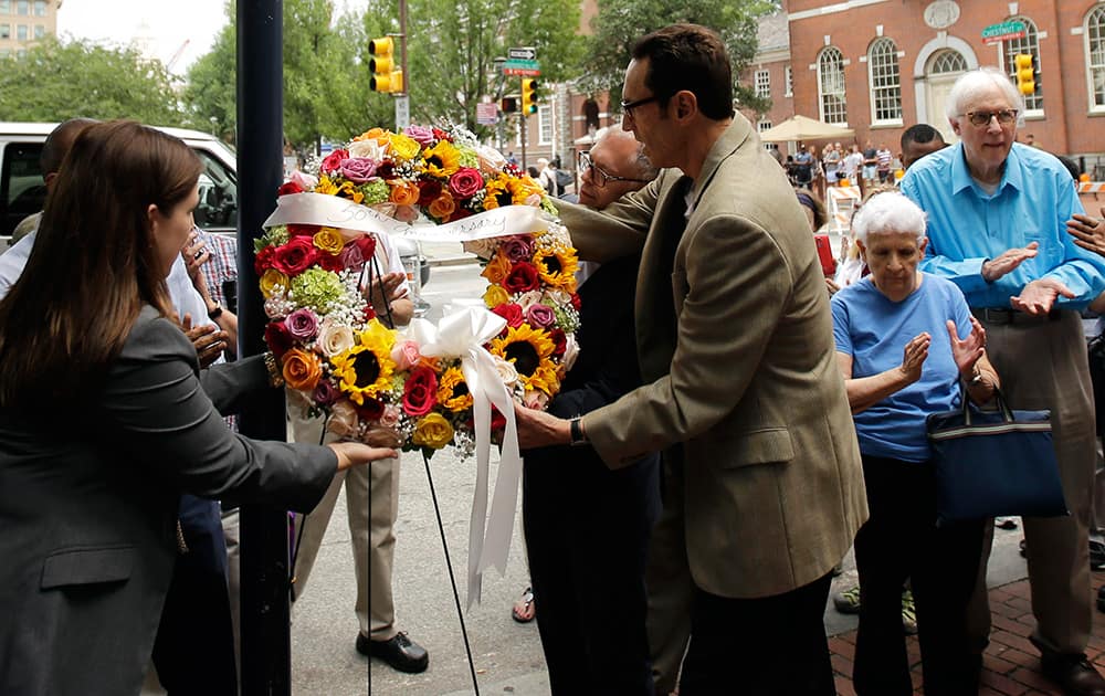 Samantha Giusti, from left, with the Delaware Valley Legacy Fund, Jim Obergefell, the man behind the landmark Supreme Court gay marriage ruling, and Malcolm Lazin, right, with the Equality Forum, hang a wreath at the Gay Pioneers historical marker across from Independence Hall and the Liberty Bell Center in Philadelphia. 