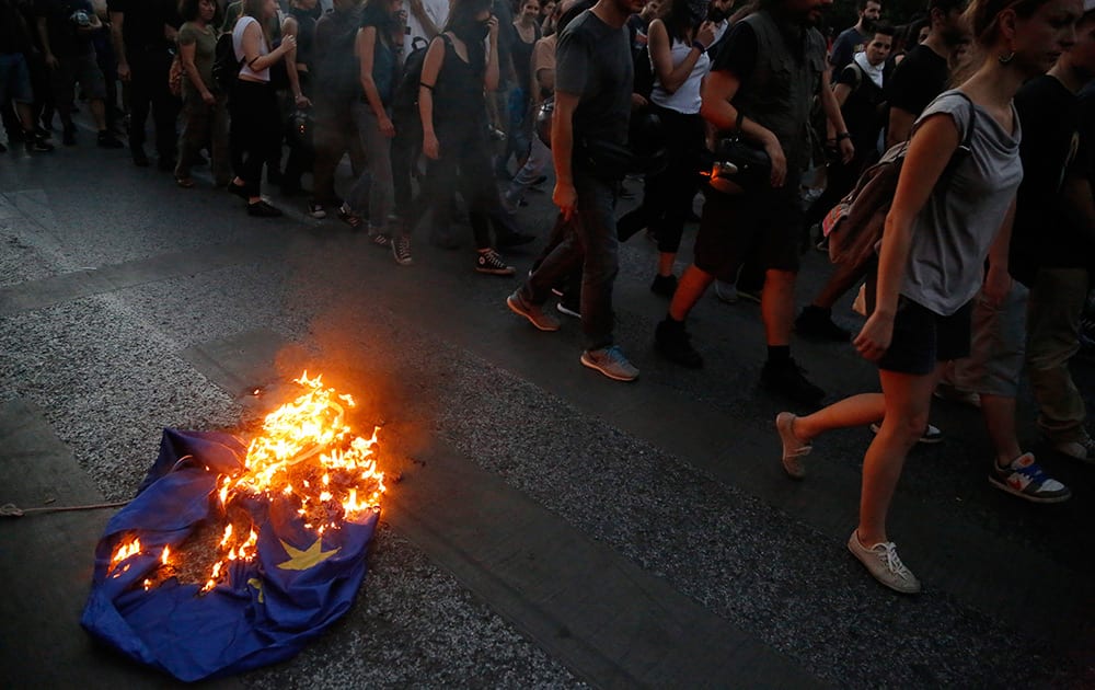 Demonstrators burn a European Union flag during a rally supporting the no vote for the upcoming referendum outside European Union office in Athens.