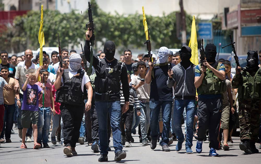 Palestinian gunmen march with their weapons during the funeral of Mohammed Kasbah, 17, who was killed by Israeli forces, during his funeral in the Qalandia refugee camp near the West Bank city of Ramallah.