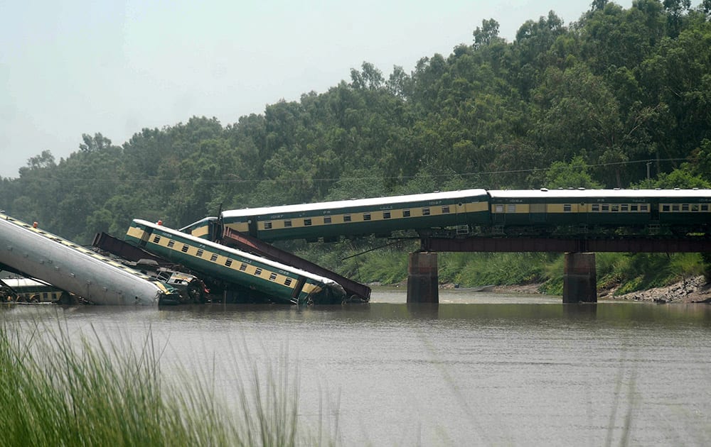 Cars of a passenger train fall after a bridge collapse led a train into a canal in Wazirabad, near Lahore, Pakistan.