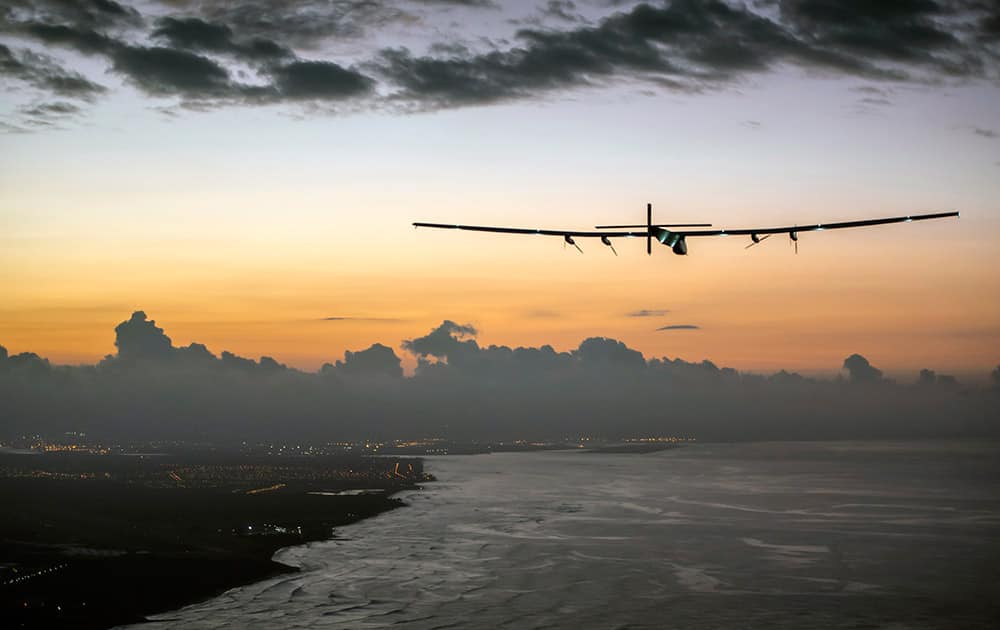 This photo provided by Jean Revillard, Solar Impulse 2, a plane powered by the sun's rays and piloted by Andre Borschberg, approaches Kalaeloa Airport near Honolulu.